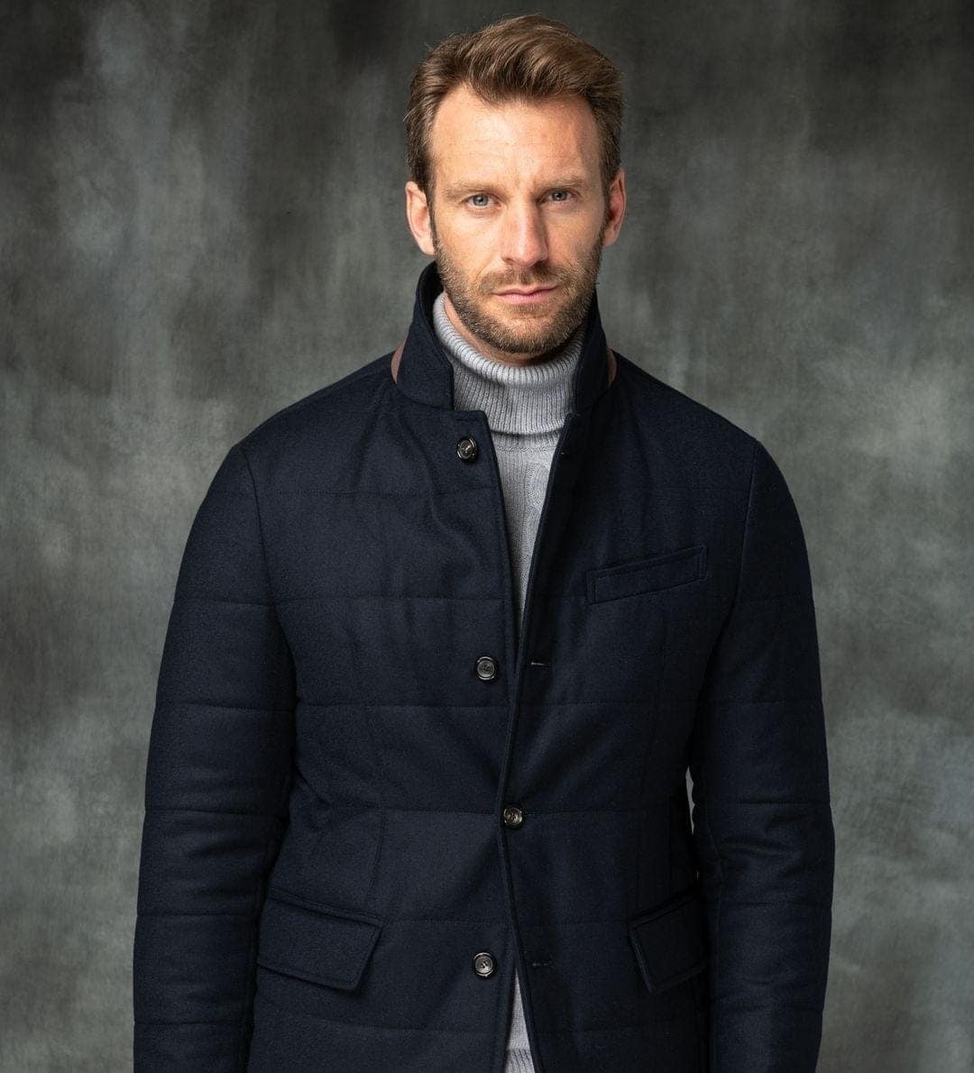 35 – Black Puffy Rain Jacket Worn Over a Grey Polo Neck